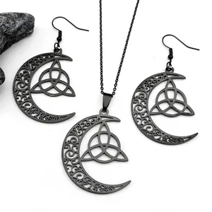 Detailaufnahme von schwarzem keltischem Dreifaltigkeitsknoten und Mondschmuck-Set auf Stein