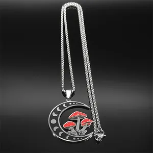 Macro detail of crescent moon pendant with red mushroom charms on a steel chain
