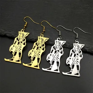 Macro view of Egyptian pharaoh pendant earrings in gold and silver on stone