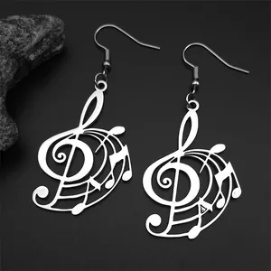 Macro shot of silver musical note earrings with treble clef design on dark stone