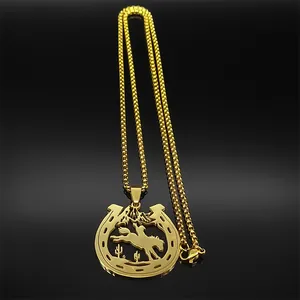 Detail shot of golden horseshoe and cowboy pendant on box chain with a desert landscape