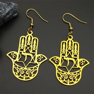 Détail macro de boucles d'oreilles Main de Fatma dorées avec motifs découpés et symbole Chai