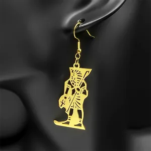 Gold Egyptian Pharaoh pendant earring with hollow metal craft on a black display stand