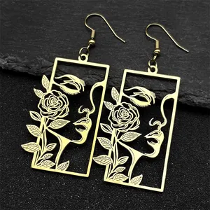 Détail macro de boucles d'oreilles dorées vintage avec portrait floral découpé