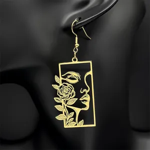 Boucles d'oreilles pendantes dorées avec portrait découpé et motif rose artistique
