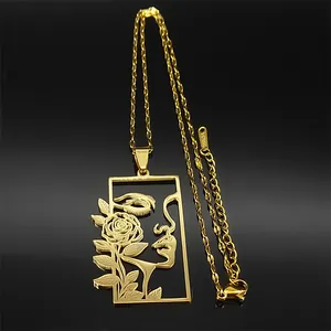 Détail du pendentif doré avec silhouette de visage de femme et rose sur fond noir