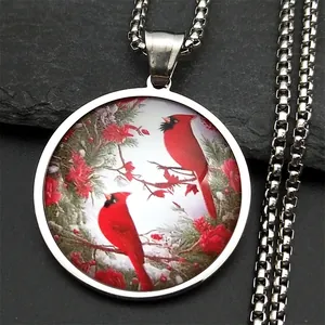 Detail of round silver pendant featuring two red cardinals on snowy pine branches