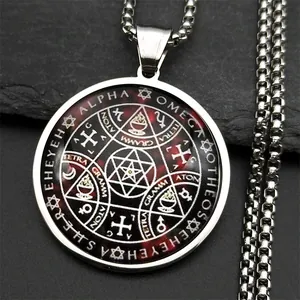 Gros plan d'un collier amulette occulte circulaire en acier titane sur roche noire