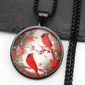 Detail of a round cardinal bird pendant featuring winter red berries on a black metal chain