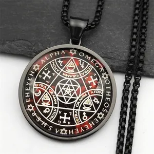 Vue détaillée du pendentif occulte noir avec symboles mystiques et chaîne sur roche