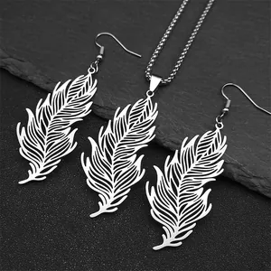Detail of silver feather jewelry set with necklace and earrings on dark stone background