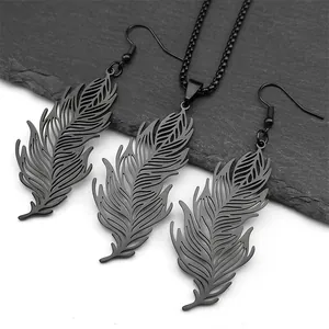 Detail view of black feather-shaped jewelry set with intricate hollowed textures and matte finish