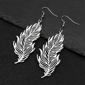 Detailed view of silver leaf feather earrings on a dark textured slate background