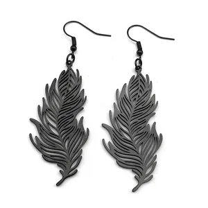 Detail view of black feather-shaped dangle earrings with intricate hollow-out design