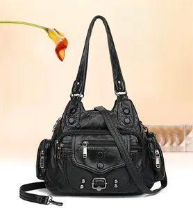 Dettaglio della borsa in pelle lavata nera con tasche a cerniera e rivetti argentati