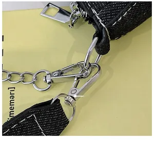 Détails du crochet métallique argenté et du zip sur le sac en jean noir Y2K star