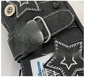 Vue détaillée du tissu en denim noir avec patchs en étoile et éléments métalliques