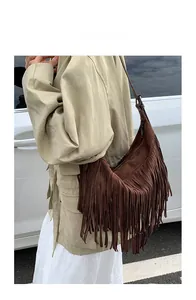 Close-up of brown suede fringe crossbody bag showing bohemian tassel texture and drape