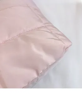 Close-up of pink quilted down fabric texture on a large capacity tote bag