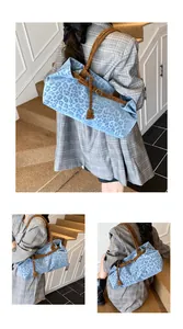 Détail d'un grand sac cabas léopard bleu avec anses brunes dans un décor élégant