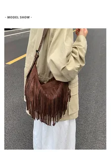 Detail of dark brown bohemian crossbody bag featuring long fringe and adjustable strap
