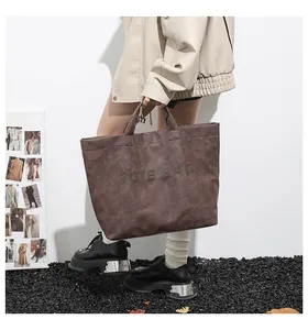 Detailed view of a dark brown vintage tote bag with TOTE BAG lettering and rivet accents