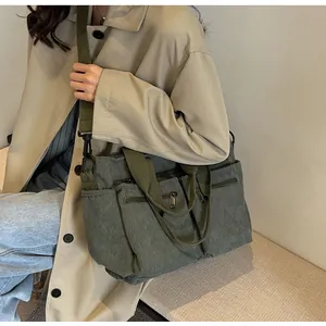 Detail of olive green corduroy tote bag with multiple zipper pockets and adjustable strap