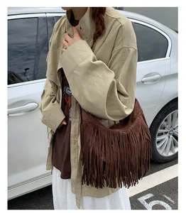 Detail view of brown suede crossbody bag with long tassels in bohemian style