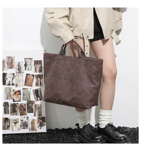 Close-up of a vintage brown tote bag with studs and stylish street fashion background