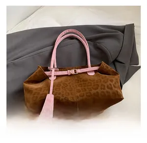 Détail du sac cabas imprimé léopard avec anses roses et boucles en métal doré