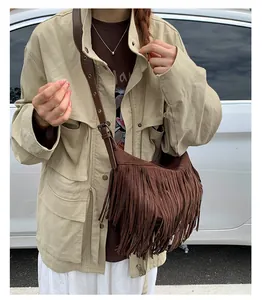 Detailed view of dark brown suede fringe bag featuring vintage tassels and metal buckle