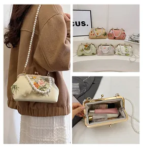 Detail of vintage floral evening bag showing pearl chain handle and interior capacity