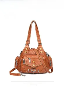 Dettaglio della borsa in pelle lavata marrone con rivetti vintage e tasche con zip