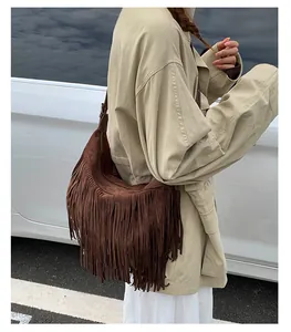 Detail of dark brown suede shoulder bag with long fringes in bohemian vintage style