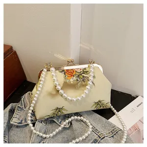 Detail of vintage kiss-lock purse with pearl handle and floral bamboo print fabric