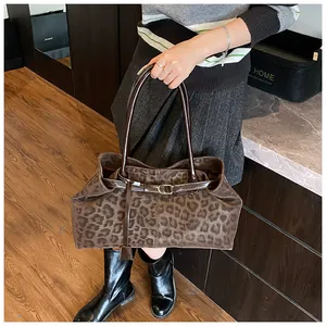 Détail du sac cabas léopard avec ceinture en cuir marron et boucle en métal doré
