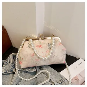 Close-up of vintage butterfly floral print bag with elegant pearl chain handles