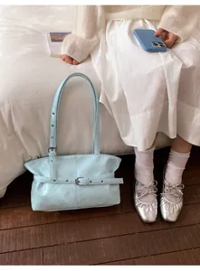 Gros plan du sac fourre-tout en cuir huilé plissé bleu clair avec une boucle métallique