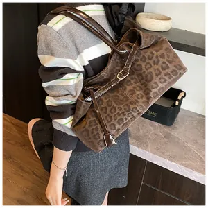 Détail du sac cabas léopard avec bandoulière en similicuir marron et boucle dorée