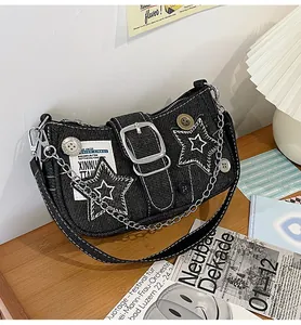 Détail du sac d'épaule Y2K en denim noir avec broderie étoile, chaînes et boucle en métal