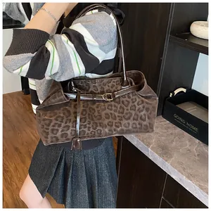 Détail du sac fourre-tout léopard avec lanières en cuir marron et boucle dorée