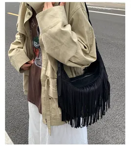 Detailed view of bohemian black fringe crossbody bag with suede texture and tassel accents