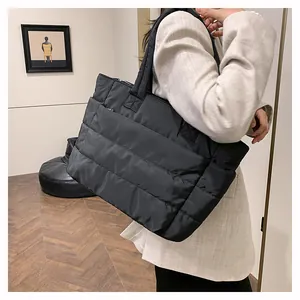 Close-up of a large black quilted tote bag with a down-like puffy texture for women