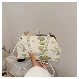 Detail of vintage style satin clutch with lotus print and elegant double pearl chains