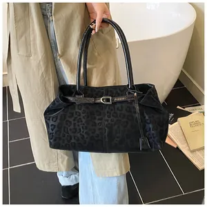 Sac fourre-tout à motif léopard avec anses en cuir dans un décor intérieur élégant