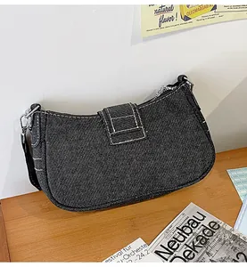 Gros plan du sac sous le bras en denim gris foncé avec surpiqûres blanches contrastées