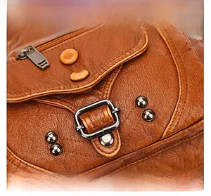 Dettaglio della borsa vintage in pelle marrone con fibbie in metallo e rivetti resistenti