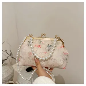 Detail of vintage butterfly print evening bag with pearl chain and gold metal clasp