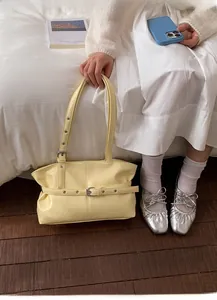 Détail du sac cabas plissé jaune clair avec boucle de ceinture et bandoulière à œillets
