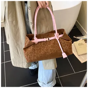 Détail du cabas imprimé léopard avec lanières en cuir rose et boucles dorées